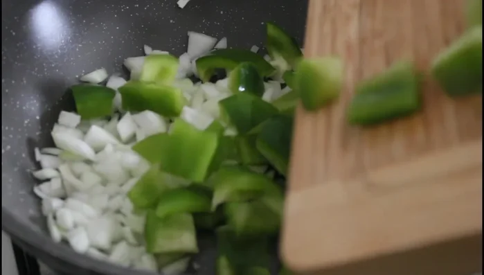 Faire revenir les oignons et les poivrons dans une poêle avec de l'huile d'olive.