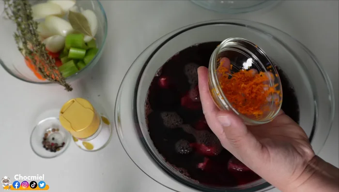 Préparer la marinade : mélanger le vin, le zeste d'orange, le poivre, le clou de girofle, le thym, l'ail, la carotte, le céleri, la feuille de laurier et l'oignon coupé en gros morceaux. Ne pas ajouter de sel à ce stade.