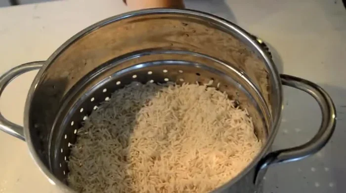 Pendant ce temps, préparer le riz : faire cuire le riz basmati dans un grand volume d'eau avec une pincée de noix de muscade, un bâton de cannelle, 4 clous de girofle, 1 cuillère à café de cardamome en poudre, des graines de fenouil et une noisette de beurre. Couvrir et laisser cuire à feu doux pendant 10 à 15 minutes.