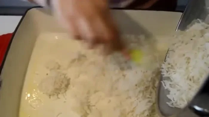 Transvaser le riz dans un plat allant au four huilé. Ajouter une noisette de beurre, du safran dilué et la sauce. Bien mélanger.