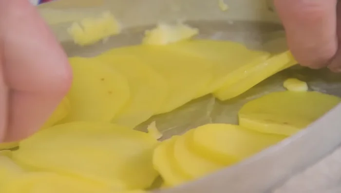 Disposer les tranches de pommes de terre dans le plat, en les chevauchant légèrement. (225.83)