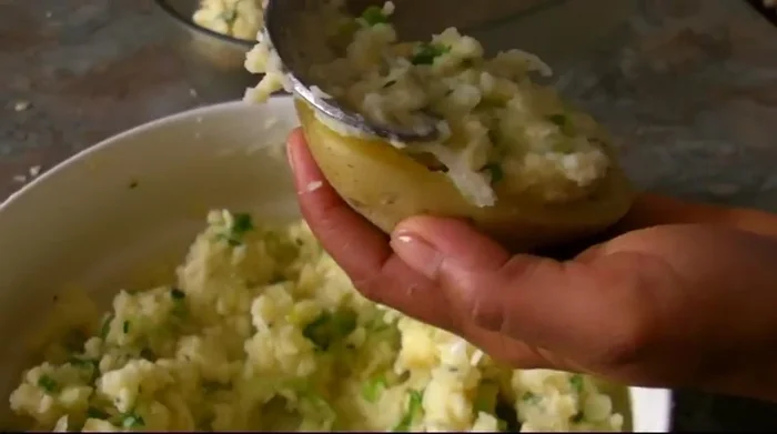 Préchauffer le four à 260°C en mode grill. Remplir les pommes de terre avec la farce, parsemer de fromage et mettre au four jusqu'à ce que le gratin soit doré.