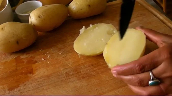Couper les pommes de terre en deux, puis les évider en laissant un bord d'environ 1 cm.