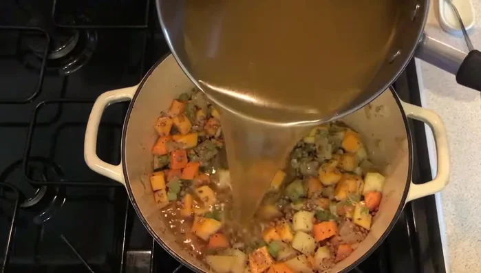 Verser le bouillon, mélanger et couvrir. Laisser cuire à feu doux pendant 30 minutes, ou jusqu'à ce que les légumes soient tendres.