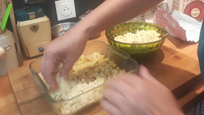 Recouvrir de la pâte à crumble. Ajouter les amandes restantes et des petits morceaux de beurre.