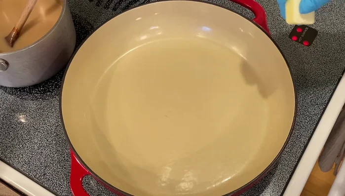 Préparation du pochage: Faire fondre du beurre dans une poêle, ajouter des échalotes hachées et de l’ail râpé. Placer les paupiettes de sole dans la poêle.