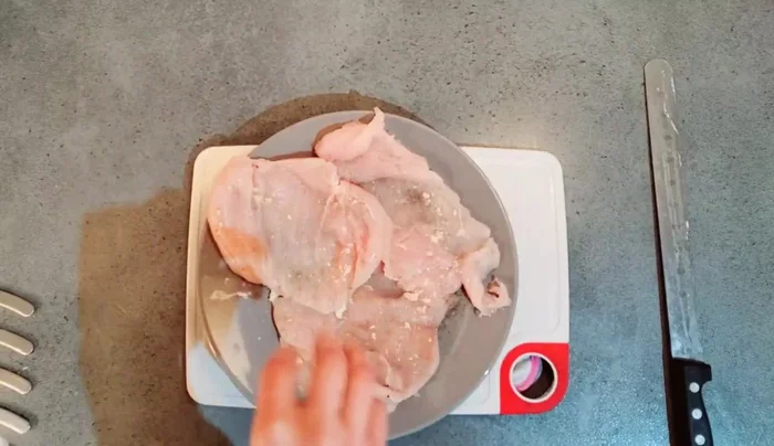 Étaler un film alimentaire. Placer un blanc de poulet, ajouter la farce refroidie et mixée, puis des morceaux de fromage. [158.6]
