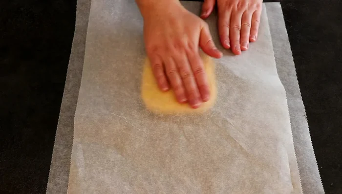 Étaler la pâte sablée entre deux feuilles de papier cuisson sur 2 à 3 mm d'épaisseur. Découper un carré de 20x20cm. Cuire à 160°C pendant 15 à 20 minutes jusqu'à coloration dorée.