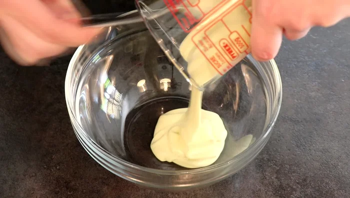 Montage de la tarte : Fouetter la crème au chocolat blanc et pistache bien froide jusqu'à obtenir une chantilly ferme. Badigeonner le biscuit à la pistache avec de la confiture de framboises chaude. Recouvrir les bords de pistaches concassées. Disposer les framboises sur le moelleux à la pistache. Dresser la chantilly à la pistache entre les framboises. Décorer avec des pistaches concassées.