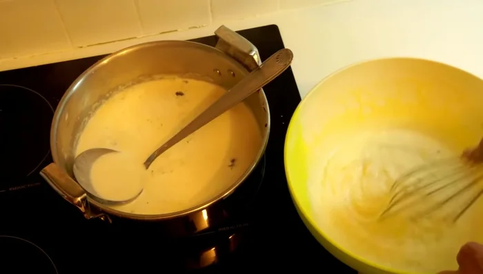 Verser un peu de crème chaude sur le mélange jaunes d’œufs/sucre/fécule, puis mélanger le tout.