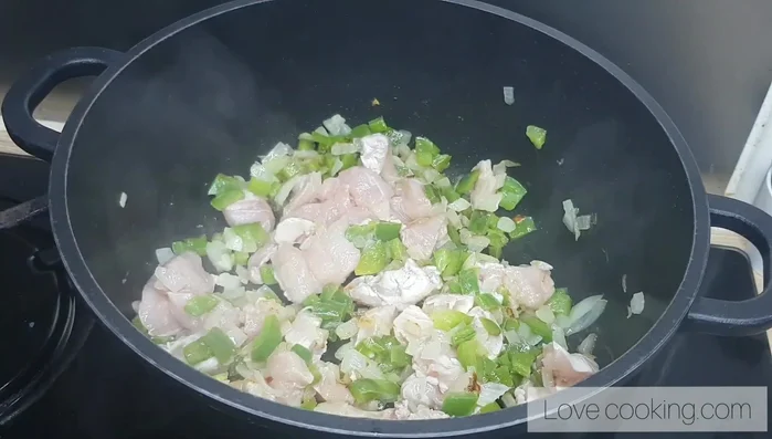 Ajouter le poulet, les épices (curry, paprika, gingembre, sel), et 100ml d'eau. Laisser mijoter 15 minutes à feu doux.