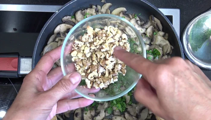 Assaisonner les champignons : Ajouter du sel, du poivre, du persil et les noix concassées. Mélanger.
