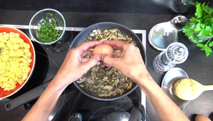 Casser les œufs : Baisser le feu. Casser 2 œufs par personne sur les champignons. Laisser cuire quelques minutes (couvrir la poêle si besoin).
