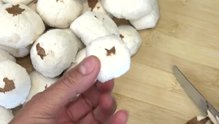 Nettoyer les champignons : les éplucher, enlever les pieds et les émincer. Ne pas les laver à l'eau.