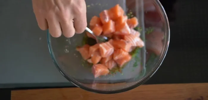 Ajouter les morceaux de saumon dans le mélange et bien mélanger pour que la préparation imprègne le poisson.