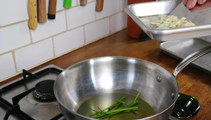 Faire revenir les tiges de persil et l'ail dans de l'huile d'olive jusqu'à ce que l'huile soit parfumée.