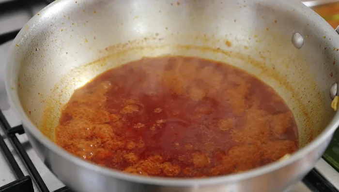 Ajouter progressivement le jus de cuisson des palourdes à la 'nduja, laisser réduire.