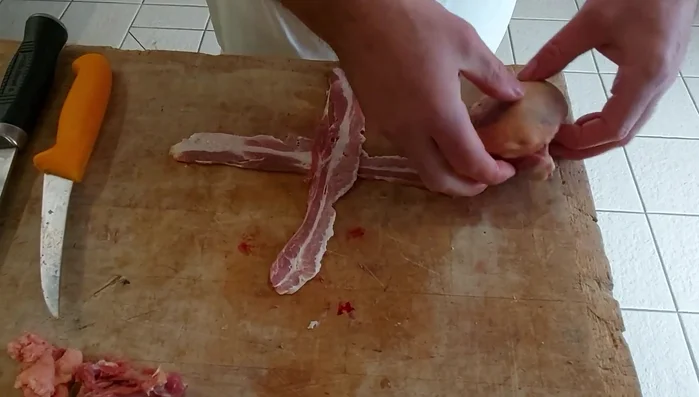 Montage de la ballotine : Superposer les suprêmes de pigeon farcis, tête-bêche. Façonner légèrement la ballotine pour lui donner une belle forme. Envelopper la ballotine dans du lard fumé en croisillons, ou dans une feuille de chou blanchie.