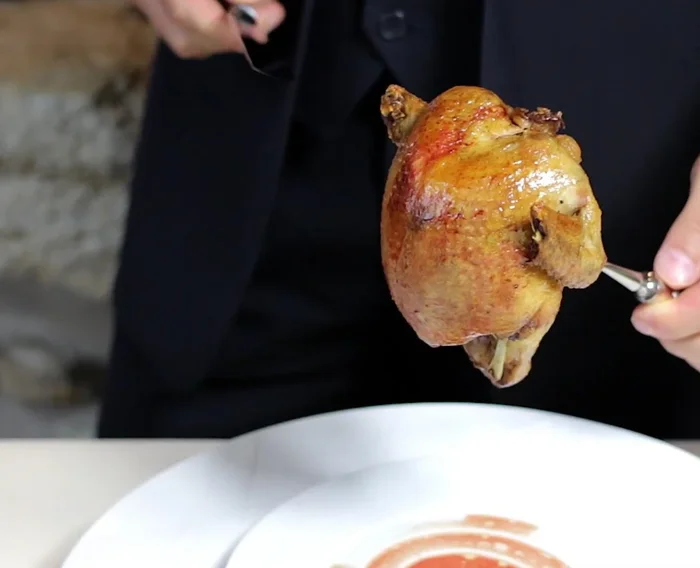 Tenir le pigeon fermement. Couper la peau qui retient la cuisse, en faisant une petite incision des deux côtés.