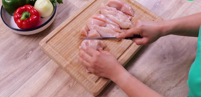 Couper chaque filet de poulet en lamelles, puis en dés.