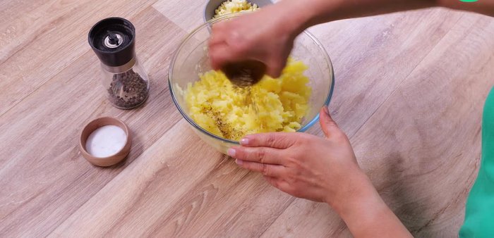 Ajouter à la purée de pommes de terre la menthe séchée, le poivre, le sel et la moitié de la mozzarella râpée. Mélanger.