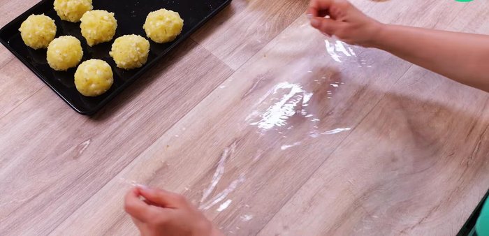 Étaler une boule de viande en cercle sur un film alimentaire. Déposer au milieu une boule de purée de pomme de terre. Enfermer l'ensemble avec le film alimentaire.