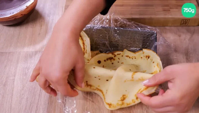 Montage : Chemiser un moule à cake avec du film alimentaire. Disposer 2-3 crêpes au fond, les bords remontant sur les côtés. Tartiner une crêpe de pâte à tartiner (ou confiture, caramel…), la rouler. Déposer le rouleau dans le moule.