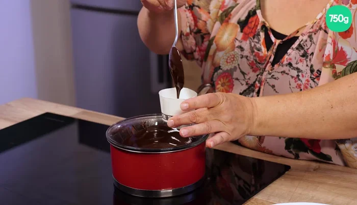 Mettre une généreuse cuillère de chocolat fondu dans chaque gobelet, en tournant pour bien répartir le chocolat sur les parois. (192.159)
