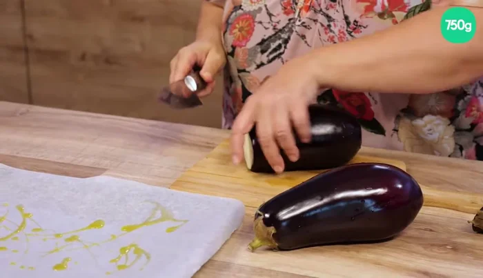 Préparer les aubergines : Couper les aubergines en tranches. Au lieu de les frire, on préfère les faire cuire au four pour utiliser moins d’huile et obtenir des aubergines fondantes. (21.279)