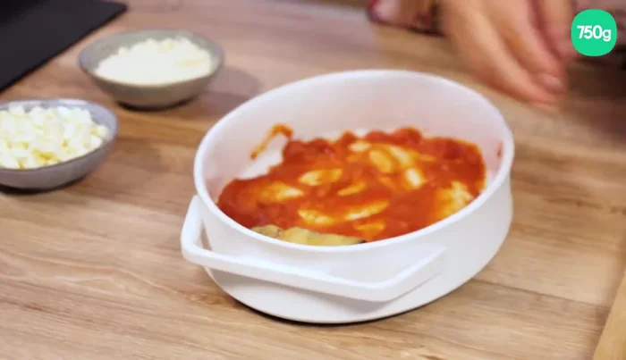 Disposer les roulades : Mettre un peu de sauce tomate au fond d'un plat à gratin. Y déposer les roulades. Ajouter un peu de sauce sur le dessus. (430)