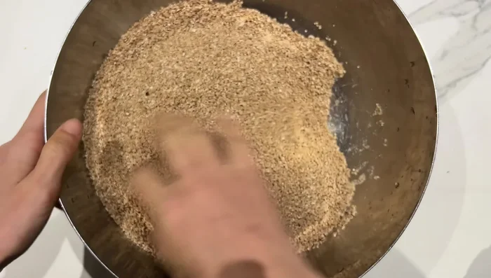 Travailler la semoule d'orge entre les mains avec un peu d'huile d'olive, puis ajouter de l'eau tiède petit à petit pour qu'elle l'absorbe (5-10 minutes).