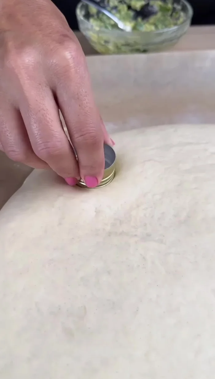À l'aide du bouchon d'une bouteille, faire délicatement des trous dans la pâte.
