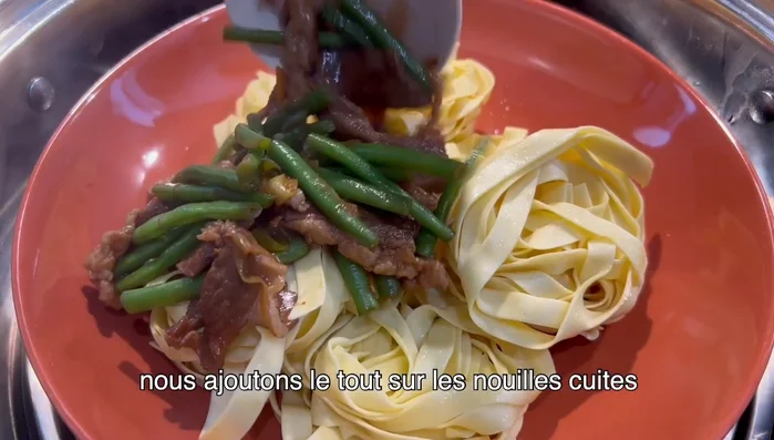 Après 5 minutes, ajouter le mélange de porc et légumes sur les nouilles cuites.