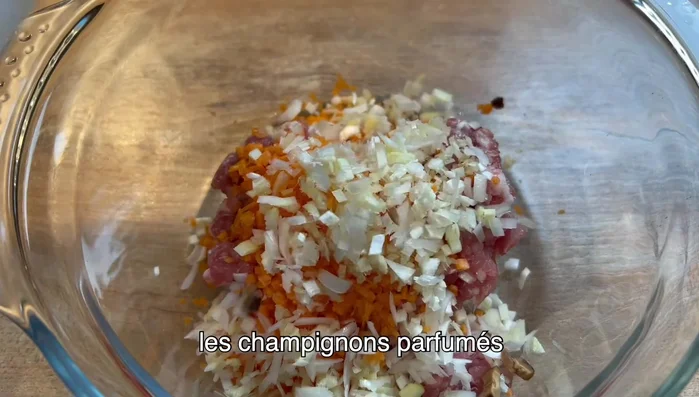 Préparez la farce en mélangeant la carotte, le gingembre, le poireau, les champignons parfumés, la sauce soja claire, de l'huile, un peu de sel et la viande.