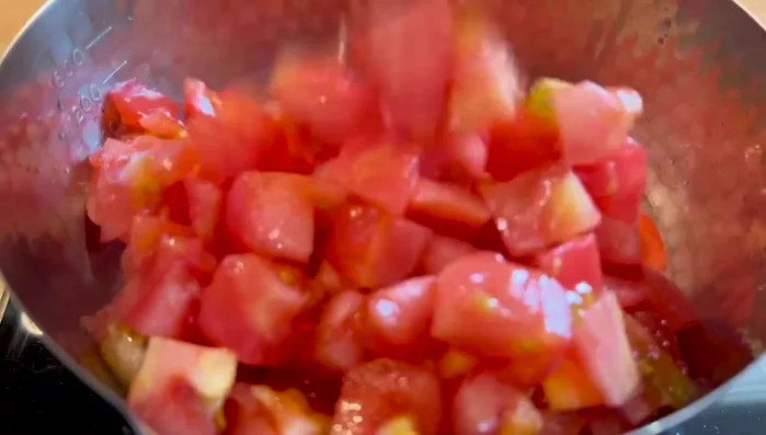 Ajouter les tomates coupées en cubes aux poireaux et à l'ail.