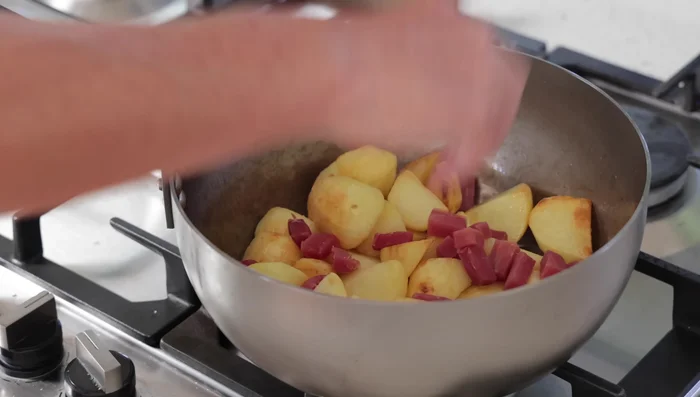 Ajouter le jambon Serrano et les oignons. Continuer à mélanger pendant 1 à 2 minutes.