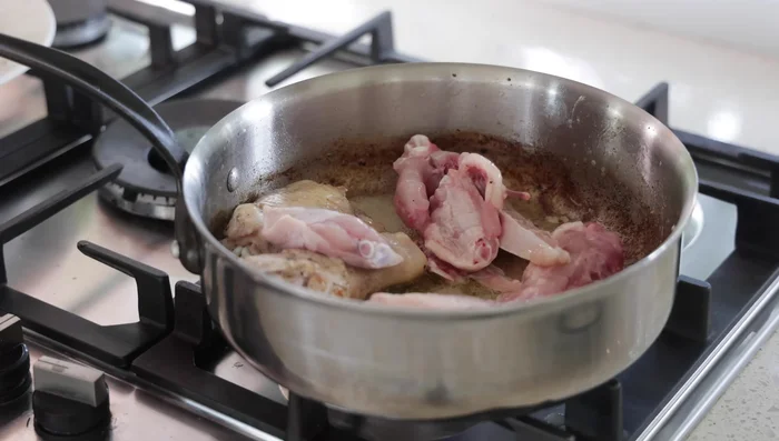 Ajouter les carcasses de poulet dans la poêle et les faire colorer légèrement.