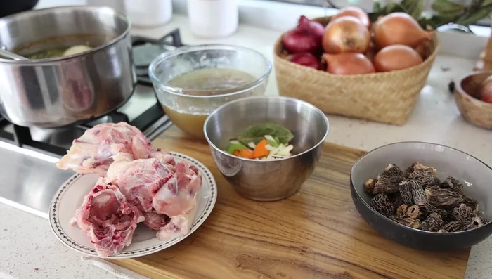 Préparer le bouillon de poulet brun : faire dorer des carcasses de poulet avec des légumes, déglacer au champagne, épaissir avec de la farine.