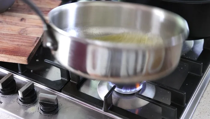 Préparer le riz au poulet : faire revenir des oignons dans du beurre, ajouter le riz, puis le bouillon de poulet blanc, une feuille de laurier, du sel et du poivre. Cuire au four à 190°C pendant environ 17 minutes.