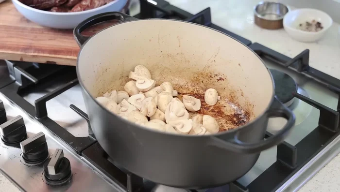 Saisir les champignons et les oignons dans la même cocotte.