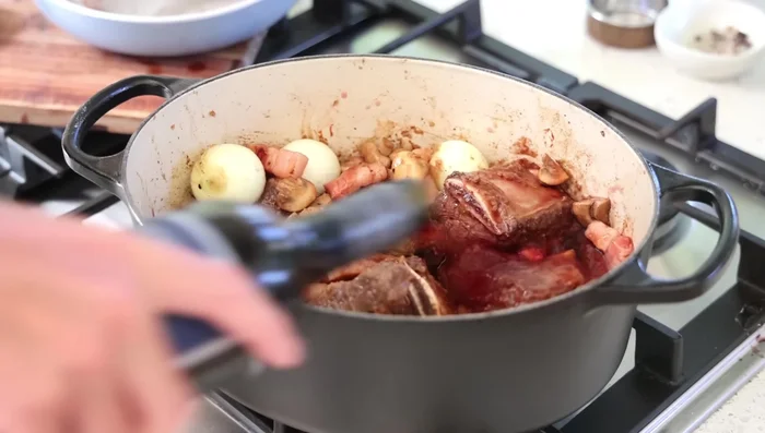 Ajouter le vin rouge et de l'eau pour couvrir la viande.
