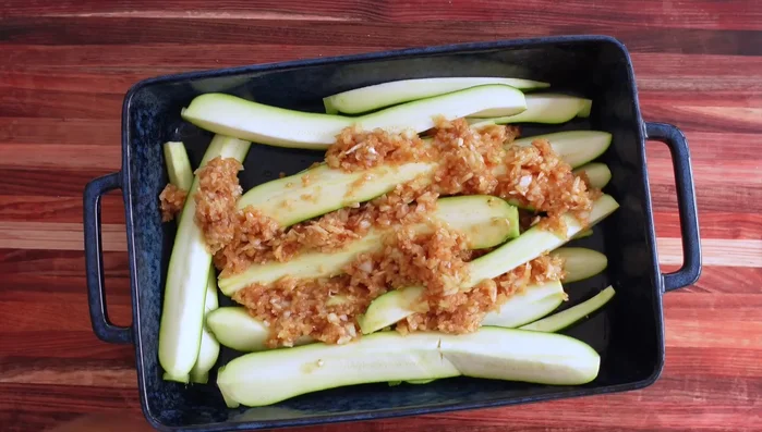 Ajouter les courgettes au mélange d'épices et bien mélanger à la main pour enrober chaque morceau.