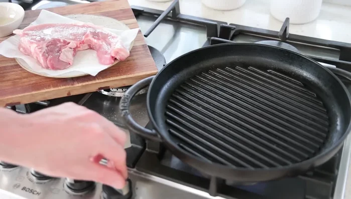 Faire cuire les côtelettes à feu moyen-élevé dans la poêle en fonte jusqu'à ce qu'elles soient bien colorées (environ 10-12 minutes, vérifier la température interne à 65°C avec un thermomètre à viande).