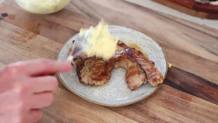 Étaler généreusement le mélange de fromage et de moutarde sur les côtelettes.