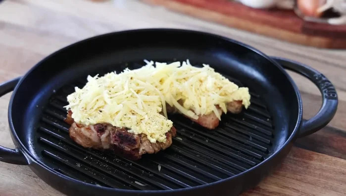 Faire griller les côtelettes au four (à un niveau légèrement inférieur pour éviter de brûler) pendant 5 minutes, ou jusqu'à ce que le fromage soit doré et croustillant.