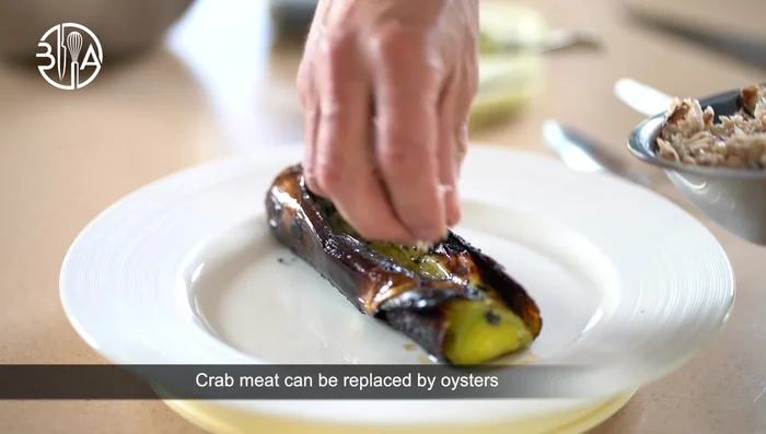 Montage : Faire une incision dans les poireaux brûlés et ajouter le beurre d'algues, la chair de crabe, la vinaigrette à la mangue et le pain TW.