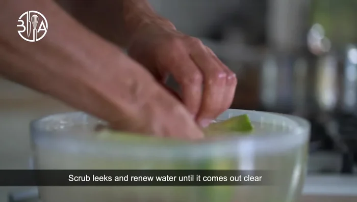 Nettoyer les poireaux : Utiliser de l'eau tiède et laisser tremper, frotter et répéter jusqu'à ce que l'eau ressorte claire.