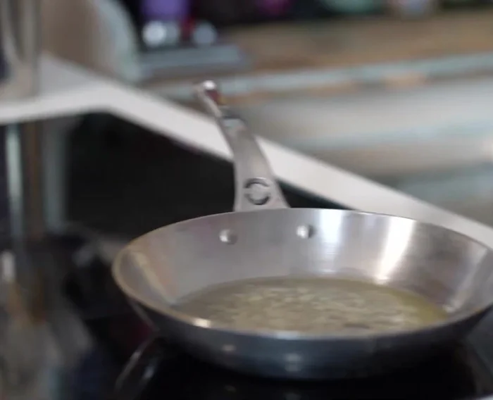Faites suer les oignons et l'ail dans du beurre. Ajoutez les pommes de terre hachées et une feuille de laurier. Faites cuire pendant environ 5 minutes.