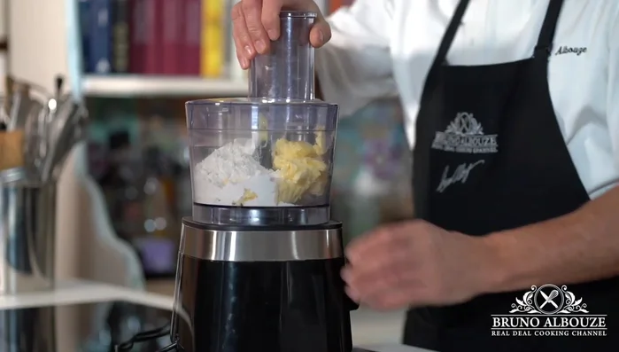 Préparer la crème d'amandes : Mélanger le beurre ramolli avec la poudre d'amandes, le sucre, les œufs et le rhum.