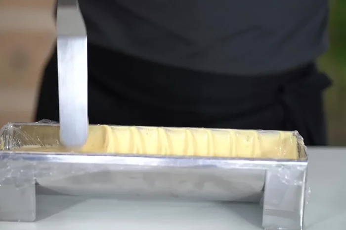 Montage (méthode 2): Remplir le moule à moitié de mousse, ajouter la compote, le biscuit hydraté, plus de mousse, congeler, démouler et glacer.